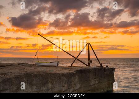 Portland Bill, Dorset, Royaume-Uni. 10 septembre 2020. Météo Royaume-Uni. Le ciel brille d'orange au lever du soleil derrière une grue sur la côte rocheuse de Portland Bill à Dorset. Crédit photo : Graham Hunt/Alamy Live News Banque D'Images