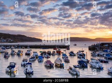 Lyme Regis, Dorset, Royaume-Uni. 10 septembre 2020. Météo au Royaume-Uni: Les bateaux amarrés dans le port de Cobb s'allument sous un beau lever de soleil automnal sur un matin froid à la station côtière de Lyme Regis que la haute pression se déplace dans la région apportant des conditions sèches et stables avant une mini-vague de chaleur prévue. Credit: Celia McMahon/Alamy Live News Banque D'Images