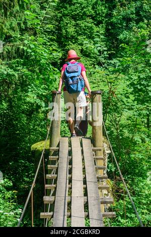 Un groupe de randonneurs traverser une petite passerelle au-dessus de la rivière Wertach près du village de Wald dans l'Allgäu Banque D'Images