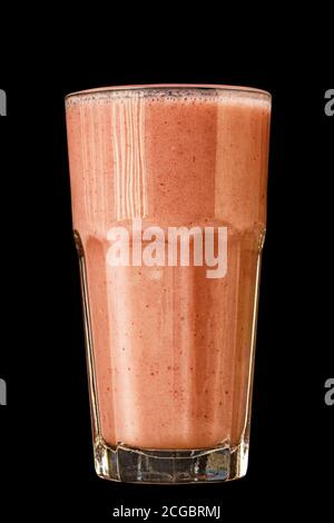 Smoothie aux agrumes d'orange dans un grand verre contre un mur en pierre sombre Banque D'Images