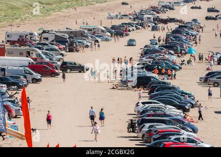 Heatwave Ireland temps ensoleillé surplombant les gens de plage sur la plage de sable et de nombreuses voitures sur Inch Beach bondée, comté de Kerry, Irlande Banque D'Images