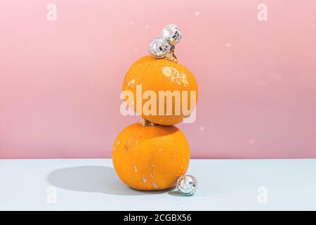 Citrouille avec boule disco sur fond bleu rose. Fête d'Halloween Banque D'Images