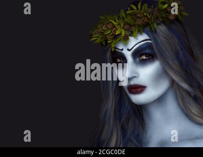 Portrait d'un horrible corpse effrayant bride en couronne avec fleurs mortes, maquillage halloween Banque D'Images