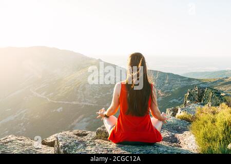 Femme pratique le yoga et médite sur la montagne. Banque D'Images