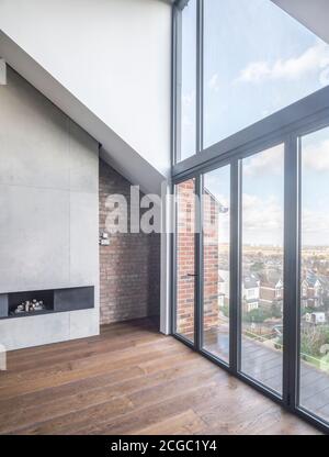 Double hauteur séjour d'un appartement rénové au dernier étage d'une grande propriété victorienne indépendante et conversion de grenier comprenant une nouvelle extension de dormeur pour former un nouveau loft de deux étages, dans le nord de Londres, Royaume-Uni. Banque D'Images