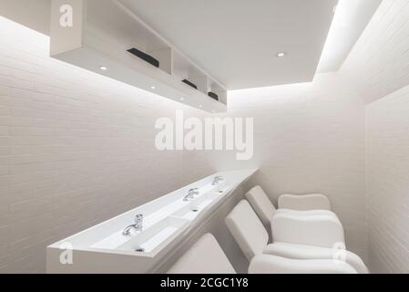 Toilettes dans un salon de coiffure de luxe entre le rez-de-chaussée et le sous-sol avec des meubles sur mesure situés au coeur de Soho, Londres, Royaume-Uni. Projet terminé en novembre 2017. Banque D'Images