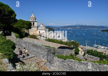 Vue imprenable sur le golfe des poètes avec l'église Saint-Laurent (XIIe siècle) et quelques randonneurs en été, Porto Venere, la Spezia, Italie Banque D'Images