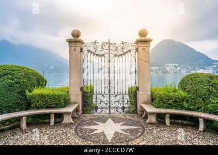 Ancienne porte en fer forgé sur les rives du lac de Lugano à Parco Civico Jardin public de Ciani et lumière spectaculaire à Lugano Tessin Suisse Banque D'Images