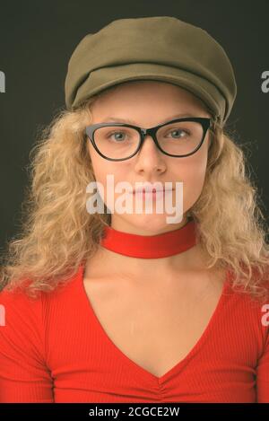 Jeune belle femme aux cheveux blonds courbés sur fond gris Banque D'Images