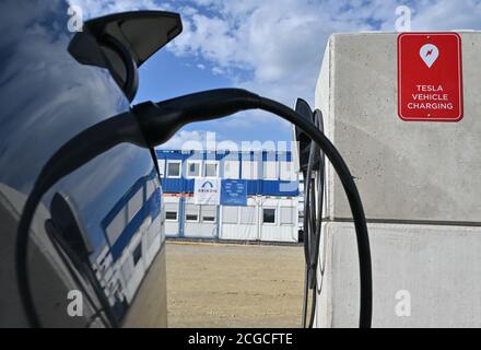 09 septembre 2020, Brandebourg, Grünheide: Dans un parking sur le site de construction du Gigafactory de Tesla, un véhicule électrique de Tesla est chargé à une station de charge. À partir de juillet 2021, un maximum de 500,000 véhicules par an doivent sortir de la chaîne de montage à l'usine - et selon les plans du constructeur automobile, le maximum doit être atteint le plus rapidement possible. Le constructeur automobile américain s'attend à ce que jusqu'à 10,500 employés travaillent par quarts dans sa première usine prévue en Europe pour l'instant. Photo: Patrick Pleul/dpa-Zentralbild/ZB Banque D'Images