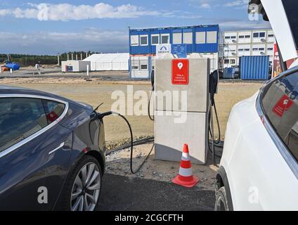 09 septembre 2020, Brandebourg, Grünheide: Dans un parking sur le site de construction du Gigafactory de Tesla, un véhicule électrique de Tesla est chargé à une station de charge. À partir de juillet 2021, un maximum de 500,000 véhicules par an doivent sortir de la chaîne de montage à l'usine - et selon les plans du constructeur automobile, le maximum doit être atteint le plus rapidement possible. Le constructeur automobile américain s'attend à ce que jusqu'à 10,500 employés travaillent par quarts dans sa première usine prévue en Europe pour l'instant. Photo: Patrick Pleul/dpa-Zentralbild/ZB Banque D'Images