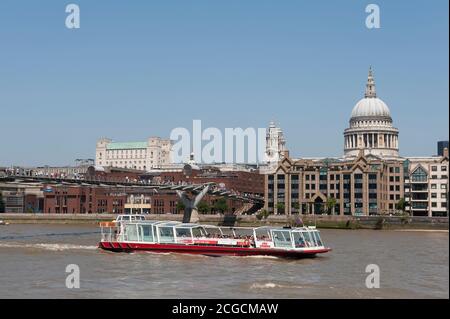 Croisières de la ville en bateau passant sous le pont du millénaire sur la Tamise avec la cathédrale St Paul en arrière-plan, ville de Londres, Angleterre. Banque D'Images