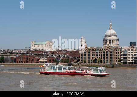 Croisières de la ville en bateau passant sous le pont du millénaire sur la Tamise avec la cathédrale St Paul en arrière-plan, ville de Londres, Angleterre. Banque D'Images