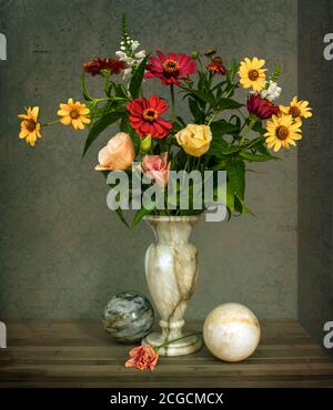 Encore la vie avec des ballons de fleurs. Un petit bouquet de fleurs différentes dans un vase en marbre et des boules de marbre. Vintage. Banque D'Images