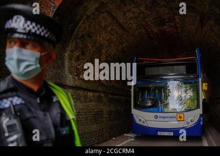 Headbourne worthy, Winchester, Royaume-Uni jeudi 10 septembre 2020. NOTE: Numberplate floue pour la sécurité UN policier se tient près de l'autobus scolaire de Stagecoach qui a eu son toit déchiré quand il s'est écrasé dans un pont de chemin de fer, blessant plusieurs enfants à Wellhouse Lane, Headbourne digne, près de Winchester, Royaume-Uni. Trois enfants ont été grièvement blessés par l'accident qui s'est produit le 8.12 jeudi matin alors que le bus emportait des élèves à l'école Henry Beaufort. Un certain nombre d'ambulanciers, d'pompiers et de policiers ont assisté à la scène. Luke MacGregor / Alamy Banque D'Images