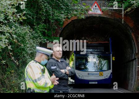 Headbourne worthy, Winchester, Royaume-Uni jeudi 10 septembre 2020. NOTE: Numberplate floue pour la sécurité UN policier se tient près de l'autobus scolaire de Stagecoach qui a eu son toit déchiré quand il s'est écrasé dans un pont de chemin de fer, blessant plusieurs enfants à Wellhouse Lane, Headbourne digne, près de Winchester, Royaume-Uni. Trois enfants ont été grièvement blessés par l'accident qui s'est produit le 8.12 jeudi matin alors que le bus emportait des élèves à l'école Henry Beaufort. Un certain nombre d'ambulanciers, d'pompiers et de policiers ont assisté à la scène. Luke MacGregor / Alamy Banque D'Images