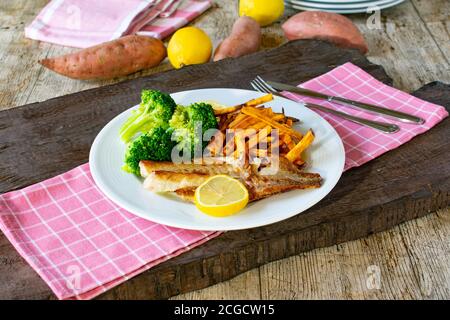 Poisson avec des patates douces et du brocoli sur une assiette Banque D'Images