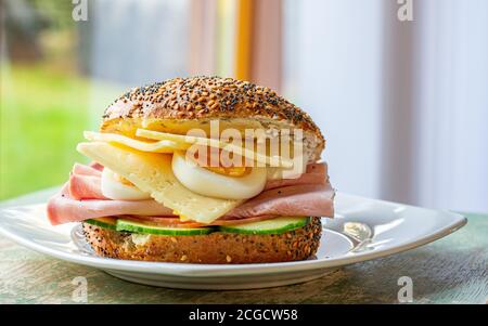 délicieux sandwich de petit déjeuner avec jambon, fromage, œufs servis sur une assiette Banque D'Images