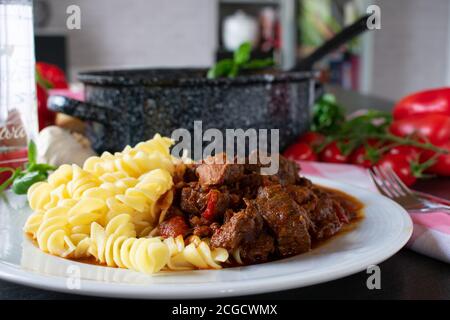 goulash hongrois servi avec des nouilles sur une assiette à la maison - recette maison Banque D'Images