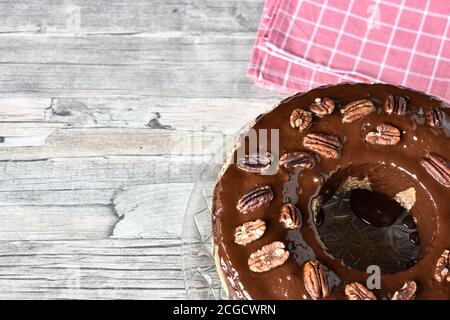 gâteau aux noix de pécan avec garniture au chocolat glacé sur une table en bois Banque D'Images