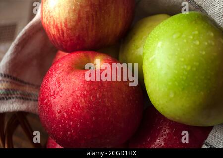 Gros plan sur les pommes rouges et vertes, plats végétariens. Récolte. Pommes dans un panier recouvert d'une serviette blanche Banque D'Images
