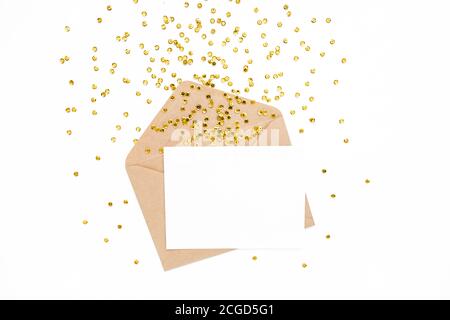 Bureau élégant avec enveloppe, carte vierge et confettis dorés isolés sur un fond blanc. Pose à plat. Modèle de maquette. Vue de dessus Banque D'Images