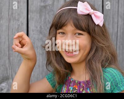 Mignon mixte-race petite fille (est asiatique / caucasien) montre avec sa main droite le signe de la main chinoise pour le numéro 9 (photo série: Image no. 9 de 10). Banque D'Images