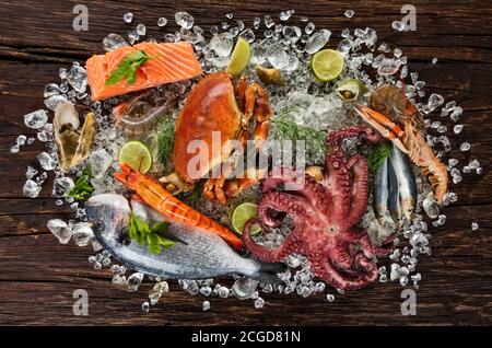 Fruits de mer frais, crabe, moules, crevettes, poisson, crabe, steak de saumon, poisson de bream et autres coquillages servis sur une ancienne table en bois Banque D'Images