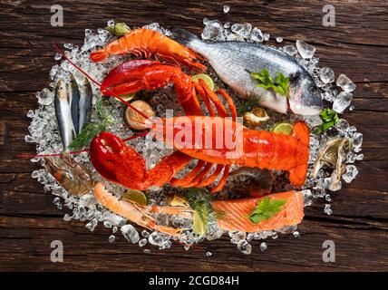 Fruits de mer frais, homard, crabe, moules, crevettes, poisson, crabe, steak de saumon, poisson de bream et autres coquillages servis sur une ancienne table en bois Banque D'Images