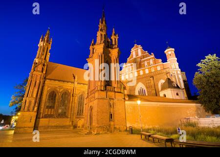 Vue nocturne de l'église Sainte-Anne illuminée de style gothique à la rue Maironio dans la vieille ville de Vilnius, Lituanie. Église Saint François et Saint Bernard Banque D'Images