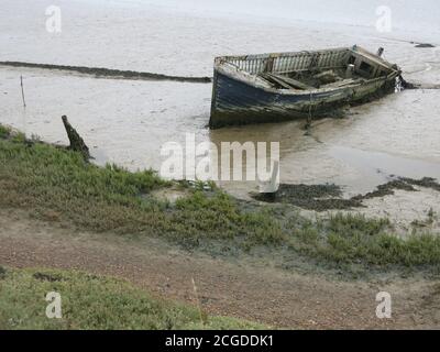 Un vieux bateau abandonné au bord de l'eau boueuse sur la rivière Ore, Orford Quay, Suffolk Banque D'Images