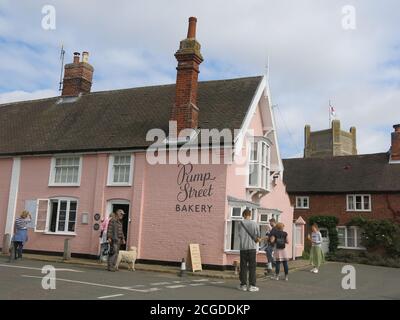 Vue sur Pump Street Bakery, un café populaire dans le village d'Orford, dans le Suffolk, également un bâtiment emblématique pour ses murs de briques peintes en rose. Banque D'Images