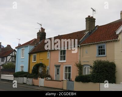 Une rangée de maisons en terrasse peintes de plusieurs couleurs sur une rue de la ville côtière d'Aldeburgh, Suffolk. Banque D'Images