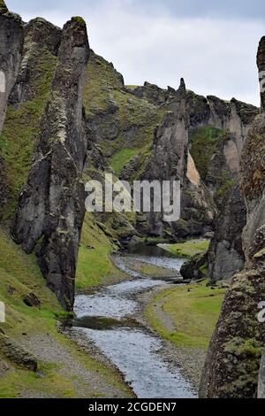 La rivière Fjaðrá traverse les falaises palagonites du canyon Fjadrargljufur. La mousse verte s'accroche à la roche. Islande du Sud. Banque D'Images