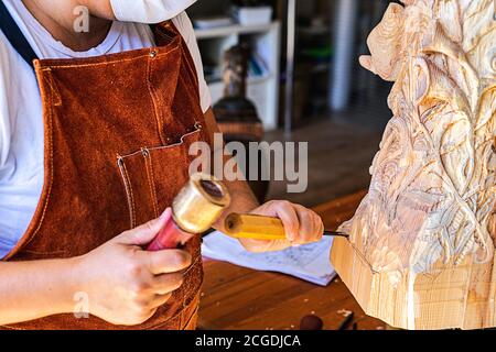 Sculpter avec masque sculptant figure en bois Banque D'Images