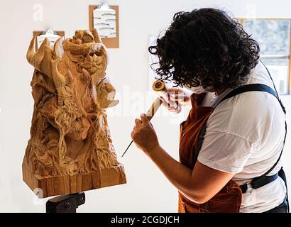 Sculpter avec masque sculptant figure en bois Banque D'Images