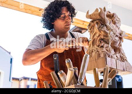 Sculptress sculptant figure en bois dans le travail Banque D'Images