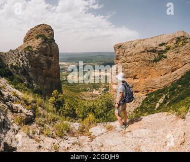 Une jeune femme athlétique s'arrête au point de vue le long de la route des Mallos de Riglos, les Pyrénées, Huesca, Aragon, Espagne Banque D'Images