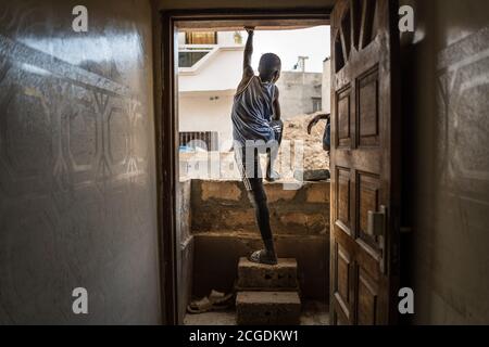 (200911) -- DAKAR, 11 septembre 2020 (Xinhua) -- UN enfant se tient sur un petit mur de briques construit pour bloquer la pluie et les inondations dans la banlieue de Dakar, Camberene, Sénégal, le 9 septembre 2020. POUR ALLER AVEC:'Feature: Sénégalais souffrent de la saison de pluie désastreuse malgré gov't aid' (photo de Louis Denga/Xinhua) Banque D'Images