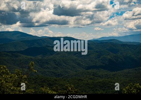 Les collines verdoyantes et enfumées de la Great Smoky Des montagnes avec des nuages de blanc qui s'obscurcissent sur un vif ciel bleu Banque D'Images