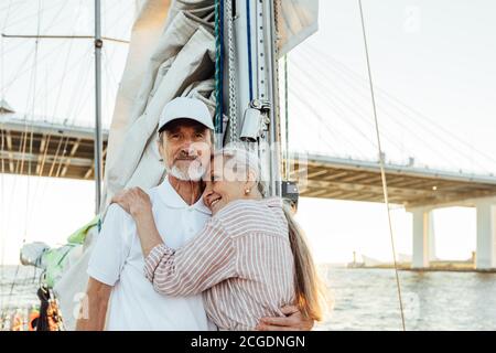Portrait d'un couple affectueux et mature qui s'embrasse en se tenant debout sur un voilier. Couple senior appréciant leurs vacances. Banque D'Images