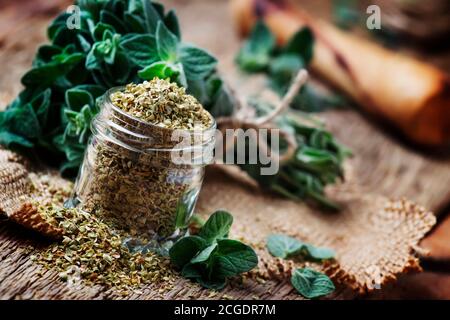 Origan sec et frais, arrière-plan en bois d'époque, style rustique, mise au point sélective Banque D'Images