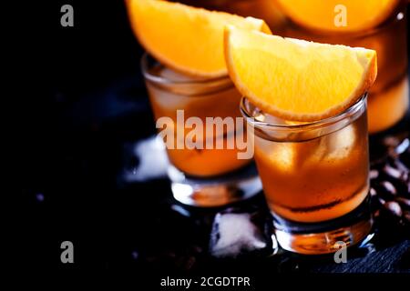 Сocktail bumblebee au jus d'orange, au sirop de caramel et au café expresso avec glaçons, fond noir, mise au point sélective, faible profondeur de champ Banque D'Images