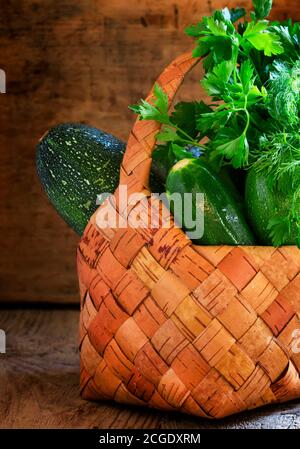 Courgettes vertes dans un panier en osier, récoltes récoltées, foyer sélectif Banque D'Images