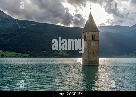 Le soleil se couche du haut de l'ancien clocher de Curon Venosta, immergé dans le lac Resia, Tyrol du Sud, Italie Banque D'Images