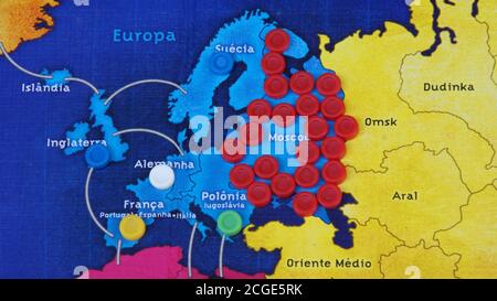 Jeu de société, avec des jetons de jeu en plastique sur une carte en carton avec une partie de l'Europe, multicolore, zoom photo, vue de dessus Banque D'Images