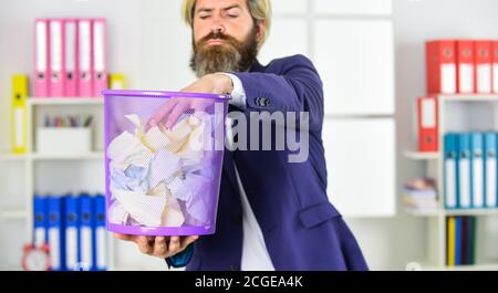 Déterminez le type et le volume de déchets de papier que votre entreprise génère. Placez les bacs de recyclage dans les zones à circulation élevée. Garde le papier hors de la décharge. Un homme d'affaires tient une poubelle. Optimiser la production de déchets. Banque D'Images