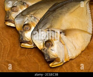 Trois vomissures fumées, reposent sur une planche en bois Banque D'Images