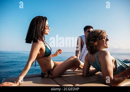 Vacances sur un voilier. Couple aimant et leur ami mâle passant du temps libre dans la mer ouverte. Les gars et la fille sur un voyage en mer sur un yacht. Jeune Banque D'Images