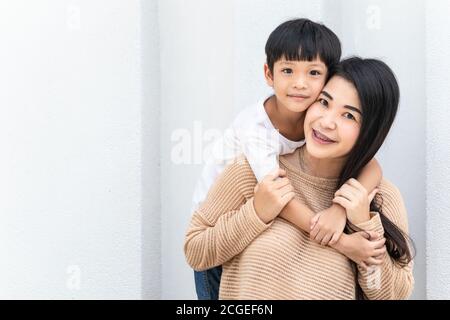 Portrait belle mère et enfant heureux embrassé. La famille asiatique maman et enfant sont embrassant et regardent l'appareil photo, mignon et chaud. Banque D'Images